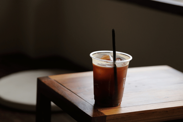 Dutch Bros Chai Drinks vs Competitors: Who Wins? 6 An iced chai drink sits on a table, without a lid, featuring a black straw for sipping.