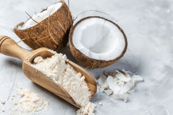 Is Buckwheat Keto Friendly? Everything You Need to Know 7 A wooden spatula holds a small pile of soft, white coconut flour, with its fine texture clearly visible.