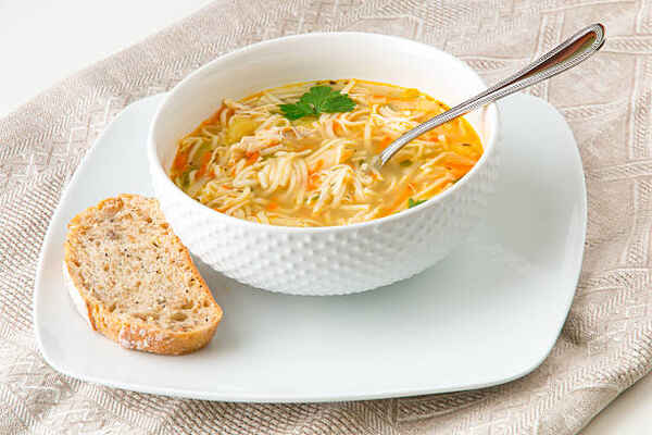 Hearty Keto Chicken Soup: Perfect Low-Carb Comfort Food 8 A bowl of chicken soup and noodles served with bread