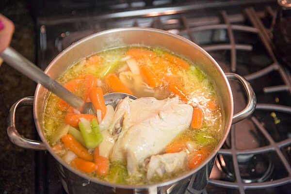 Hearty Keto Chicken Soup: Perfect Low-Carb Comfort Food 5 Cooking chicken soup with vegetables on stovetop