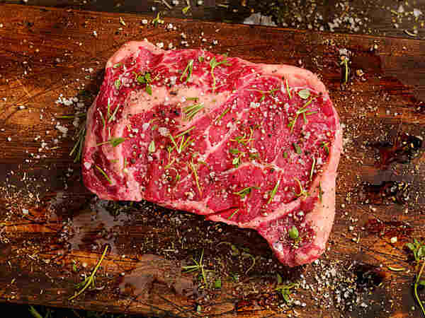 Flavorful Keto Steaks: Easy Recipes for Low-Carb Meals 8 Raw ribeye steak seasoned with salt, pepper, and herbs