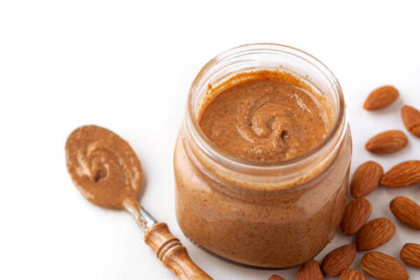 Almond butter in a glass jar with a spoon