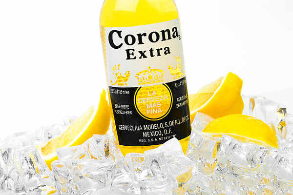 A bottle of Corona Extra with ice cubes and lemon slices