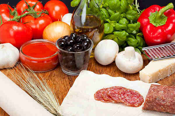 Crustless Pizza: Quick, Easy, and Delicious Low-Carb Pizza 2 Pizza ingredients including tomatoes, garlic, onion, mushrooms, olives, and cheese without crust