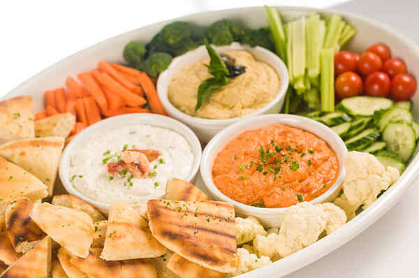 Appetizer dips served with chips and vegetables