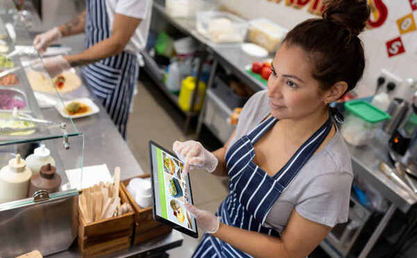 Best Sugar-Free Fast Food Options for a Healthier Diet 23 A woman in fast food taking an order on a tablet