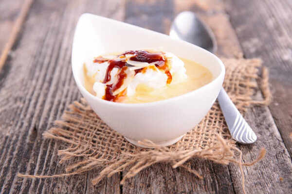 Homemade floating island dessert in a bowl topped with caramel sauce