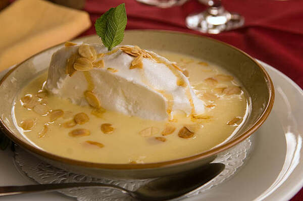 Floating island dessert topped with caramel and almonds