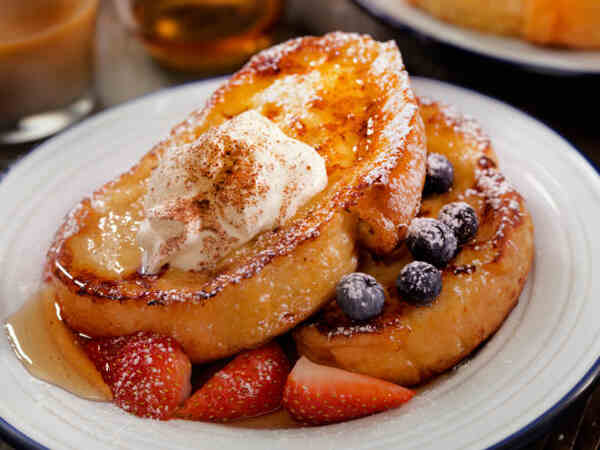 Easy Low-Carb French Toast Recipe for a Keto Breakfast 6 French toast served with syrup, whipped cream, and berries