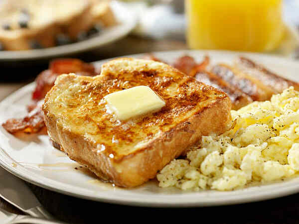 Easy Low-Carb French Toast Recipe for a Keto Breakfast 3 French toast with maple syrup and butter served with eggs and bacon