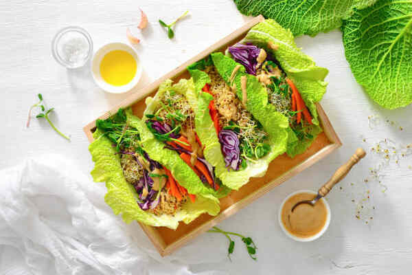 Keto Spring Rolls with Peanut Sauce You’ll Crave Daily 6 Fresh spring roll ingredients in lettuce wrappers with sauce