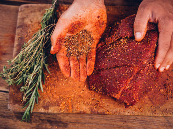Best Rub for Ribs That Brings Big BBQ Flavor Fast 5 Hands coating raw pork with dry rub seasoning