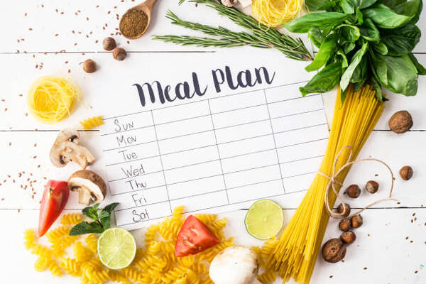 How to Plan a Cheat Day on Keto Without Guilt 5 A meal plan for a week on a white table among products for cooking