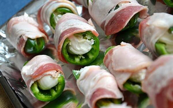 Easy Keto Jalapeno Poppers Recipe for a Spicy Snack 6 Raw jalapeno peppers, stuffed with cream cheese and wrapped with bacon on a lined baking sheet
