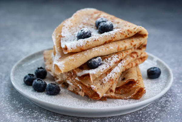 Easy Low-Carb Crepes Recipe with Just 4 Ingredients 8 Homemade crepes served with blueberries and powdered sugar on a plate