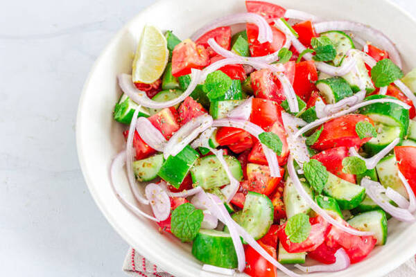Easy Keto Cucumber Tomato Salad for Fresh Summer Flavor 2 Tomato cucumber onion salad in a bowl with herbs