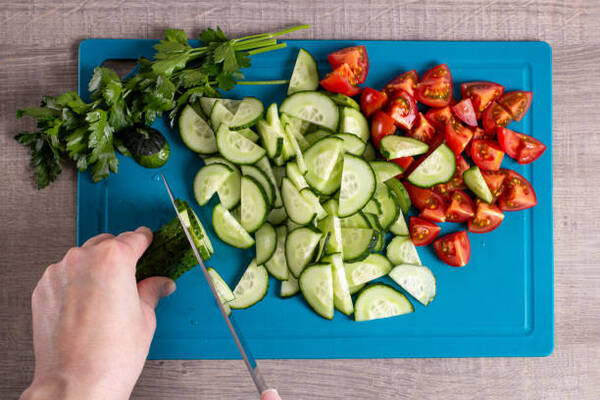 Easy Keto Cucumber Tomato Salad for Fresh Summer Flavor 6 Slicing tomatoes and cucumbers on a chopping board