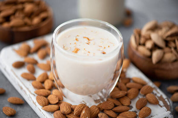 Easy Almond Milk Ice Cream Recipe with Just 4 Ingredients 4 Homemade almond milk in a glass on a white wooden board