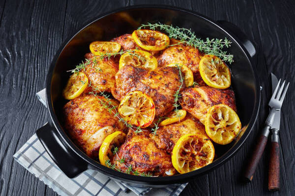 Calories in Chicken Thigh Made Simple: Nutrition Breakdown 8 Baked chicken thighs with roasted lemon slices and thyme in a black ceramic dutch oven