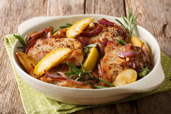 Easy 4-Ingredient Oven-Baked Pork Chops for Busy Nights 2 Baked pork chops with green apples, onions, and rosemary in a baking dish