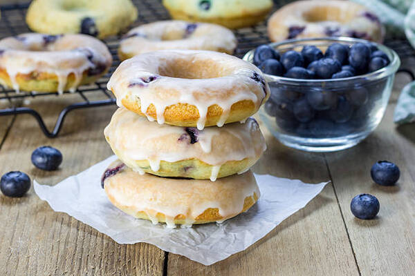 Easy Keto Lemon Blueberry Bread Recipe for a Sweet Treat 8 Freshly baked baked donuts with blueberries and lemon glaze, for breakfast