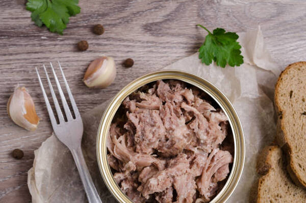 Is Canned Chicken Healthy? What You Need to Know 2 Canned meat fillet in a metal can with garlic cloves and pepper