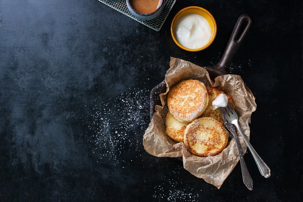 Keto English Muffin Recipe for Quick Breakfasts 6 A keto English muffin rests on parchment paper in a pan, with pork and a knife placed beside it