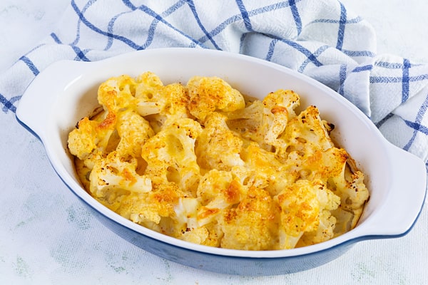 Cauliflower Bake: Deliciously Cheesy and Healthy Recipe 9 A creamy baked cauliflower dish with a golden cheese topping, served in a white and blue baking dish