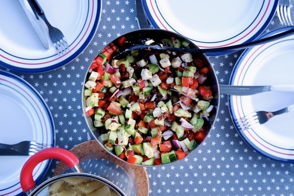 Easy Red White and Blue Salad Recipe for Your BBQ 9 A bowl of red white and blue salad with chopped cucumbers, tomatoes, onions, and feta cheese