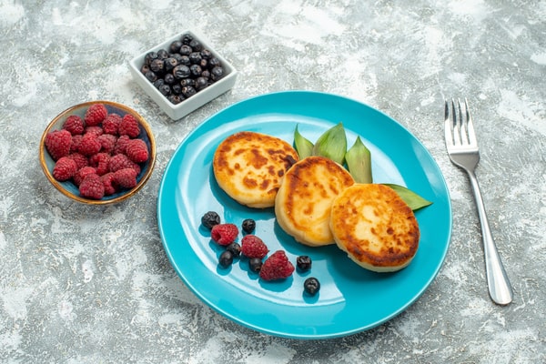 Keto English Muffin Recipe for Quick Breakfasts 10 A plate of English muffins is served with sides of berries and blackberries