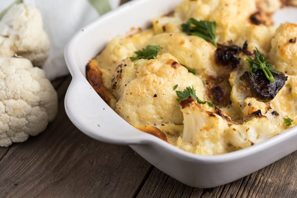 Cauliflower Bake: Deliciously Cheesy and Healthy Recipe 10 A creamy and golden-baked cauliflower dish, garnished with fresh parsley, served in a white baking dish