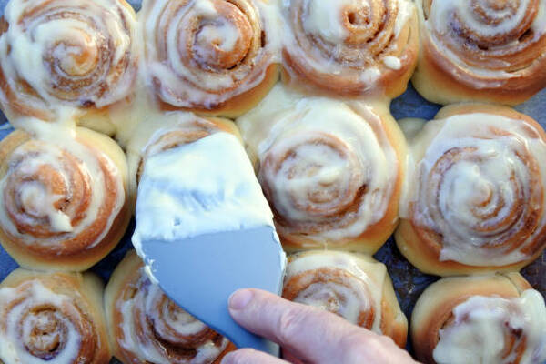 Easy Keto Cinnamon Buns Recipe for Sweet Indulgence 9 Adding cream cheese frosting on baked cinnamon rolls