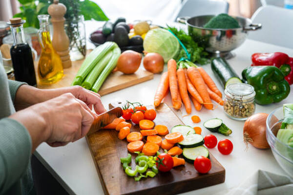 Exploring the Vegetarian Paleo Diet: What You Need to Know 9 Close up of woman's hands slicing fresh vegetables on kitchen counter