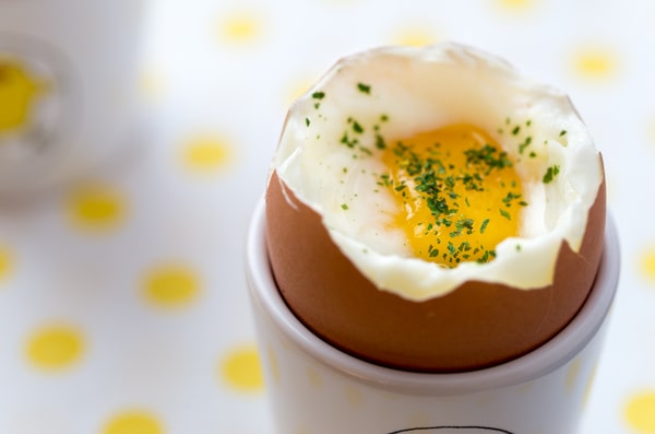 Keto Egg Cups: A Quick Breakfast Solution 6 Soft-boiled keto egg cup served in an eggshell, topped with chopped herbs