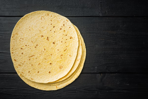 Are Corn Tortillas Keto or Just a Carb Trap? 6 A stack of tortillas placed on a dark wooden surface
