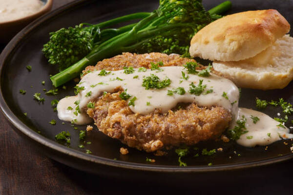 Perfect Keto Chicken Fried Steak with a Creamy Gravy Twist 3 Chicken fried steaks with country style gravy, broccolini, and a biscuit
