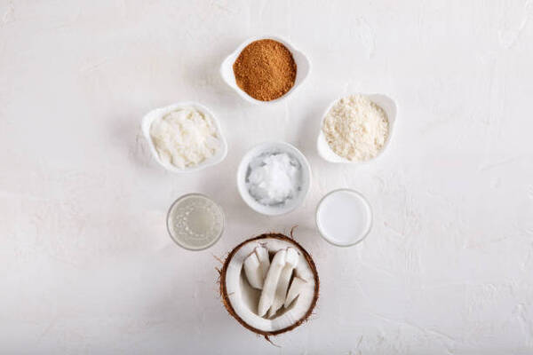 Is Coconut Sugar Keto or Just Another Sweetener Trap? 3 Coconut products, coconut oil, water, milk, sugar, flakes, and flour in separate bowls