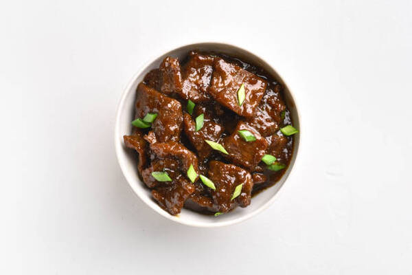 Easy Mongolian Beef Recipe You Can Make at Home Tonight 2 Mongolian beef stewed in soy sauce with spices served in a white bowl
