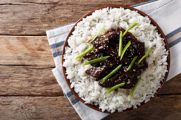 Easy Mongolian Beef Recipe You Can Make at Home Tonight 7 Mongolian beef with sauce and garnish of rice on a plate