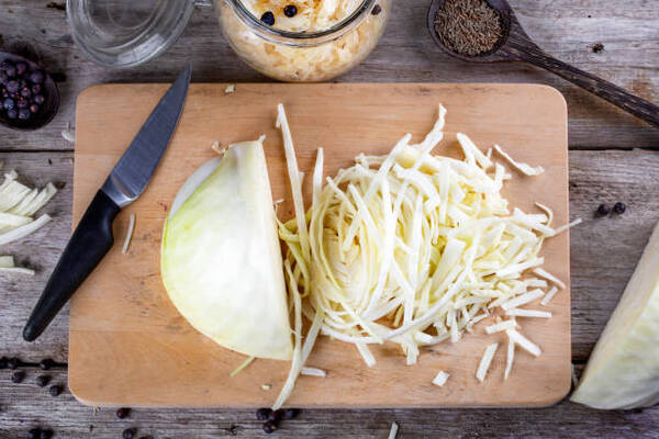 Is Sauerkraut Keto or Not? What You Need to Know 4 Slicing cabbage on a cutting board for a Sauerkraut