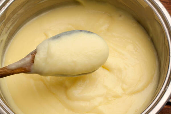 Mixing vanilla custard in a bowl with a wooden spoon